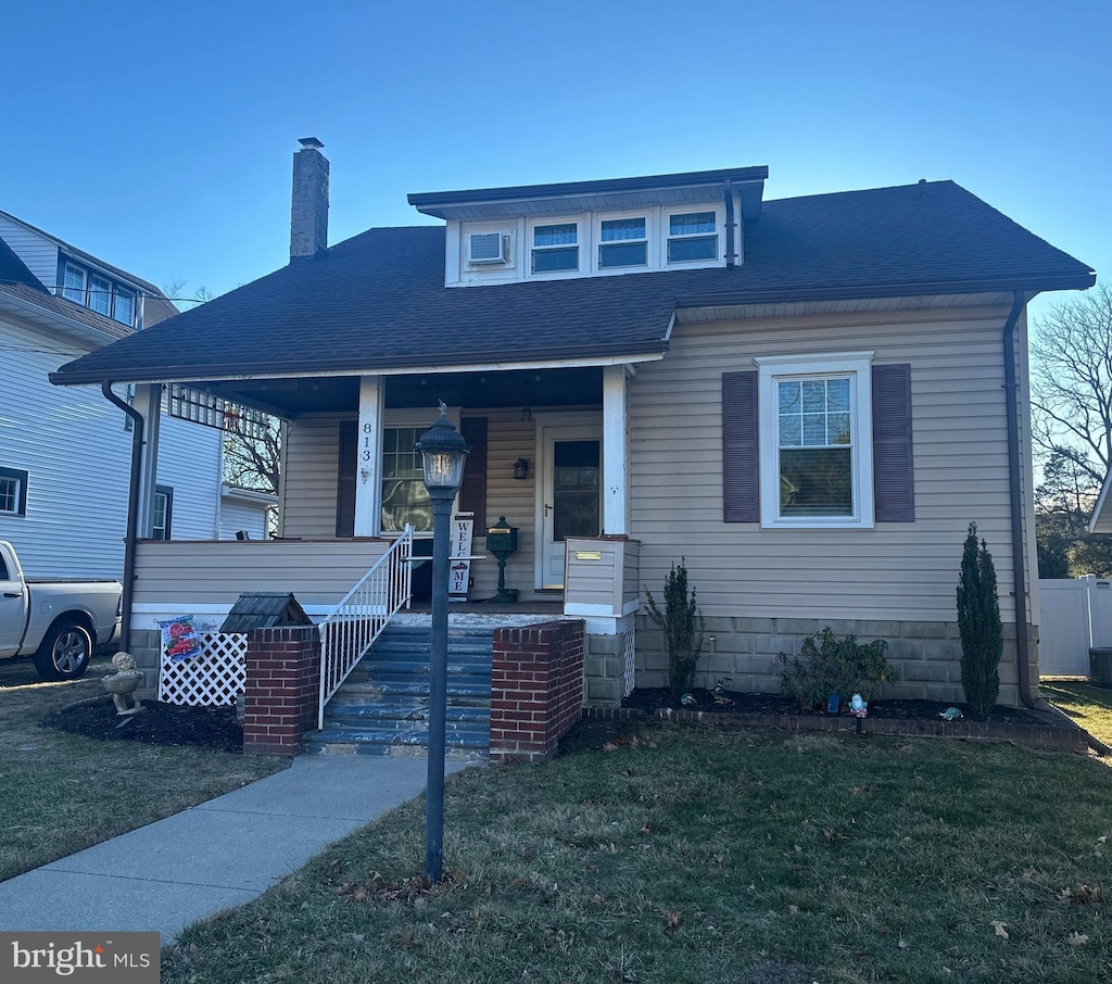 view of front of property with a porch and a front lawn