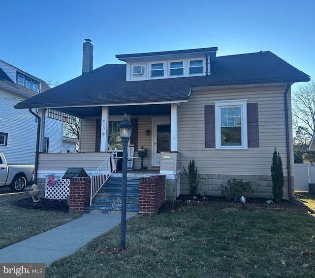 view of front of property with a porch and a front lawn