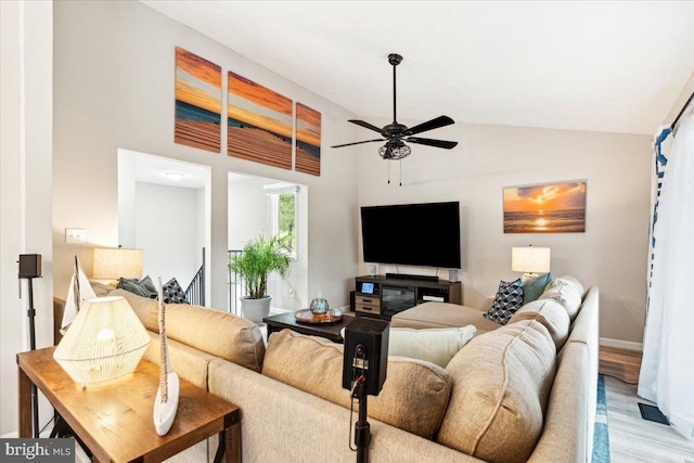 living room featuring light hardwood / wood-style flooring, high vaulted ceiling, and ceiling fan