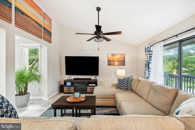 living room featuring ceiling fan, lofted ceiling, and light hardwood / wood-style floors