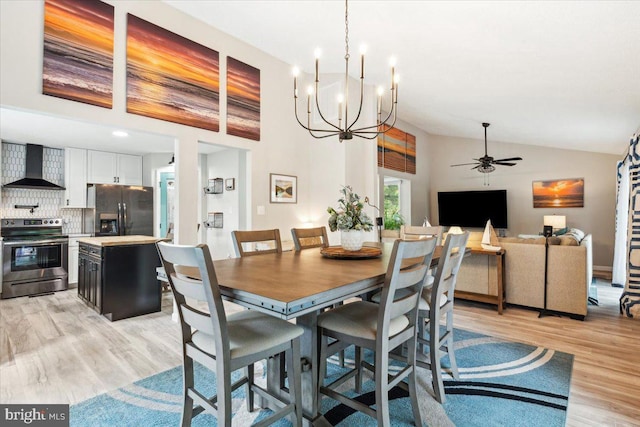 dining room featuring high vaulted ceiling, ceiling fan, and light wood-type flooring