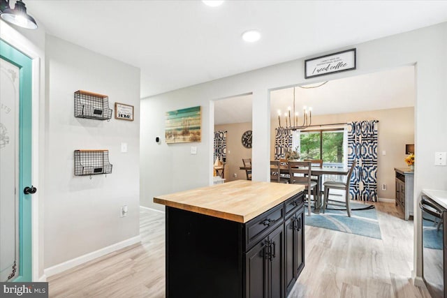 kitchen featuring hanging light fixtures, a center island, wooden counters, and light hardwood / wood-style floors