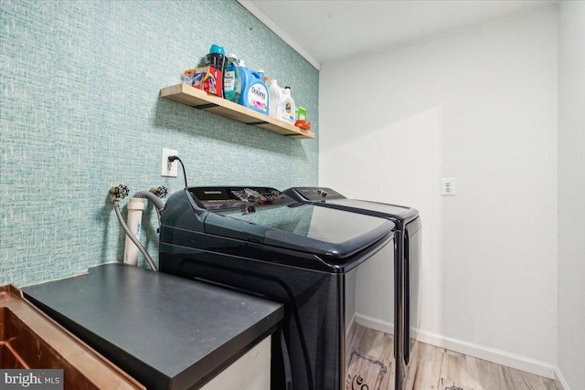 clothes washing area with wood-type flooring and separate washer and dryer