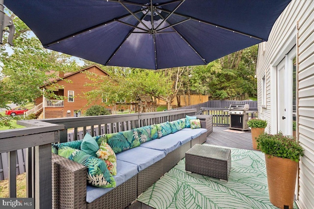 wooden deck featuring grilling area and an outdoor hangout area