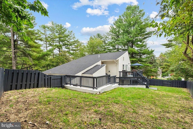 rear view of house with a yard and a deck