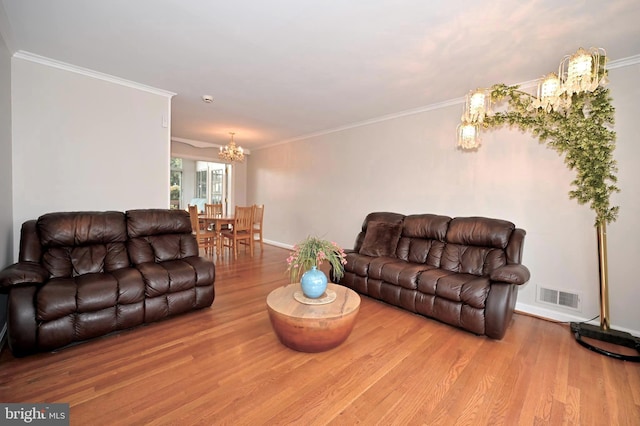 living room featuring hardwood / wood-style flooring, crown molding, and a notable chandelier