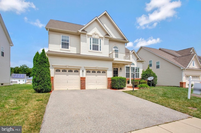 view of front of home with a garage, a balcony, and a front yard