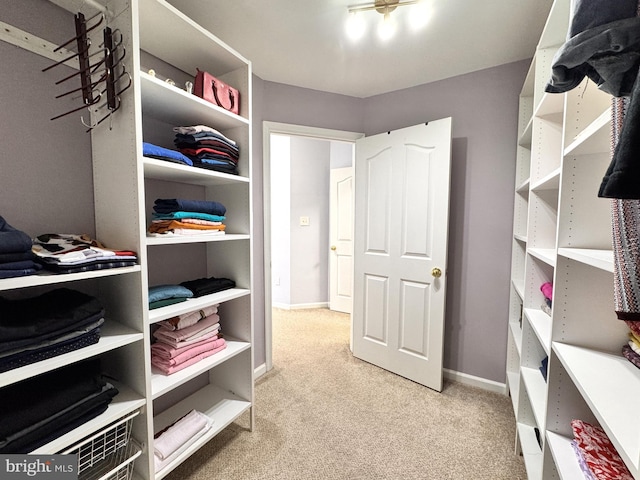 spacious closet featuring light colored carpet