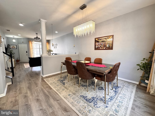 dining space featuring decorative columns and hardwood / wood-style floors