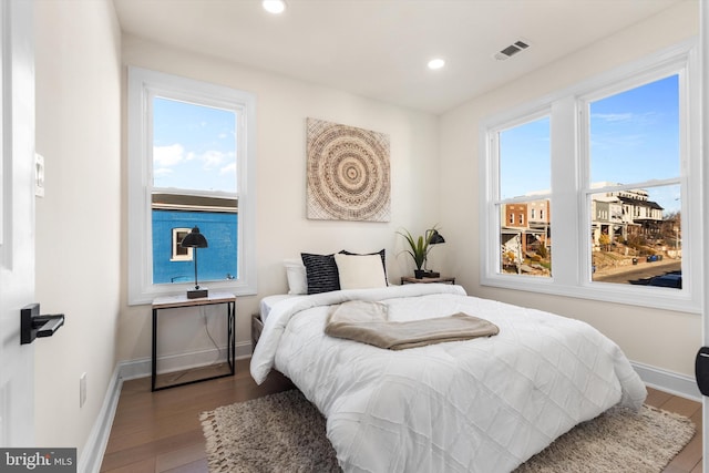 bedroom with multiple windows and hardwood / wood-style floors