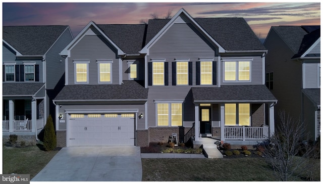 view of front facade featuring driveway, a garage, a porch, and brick siding