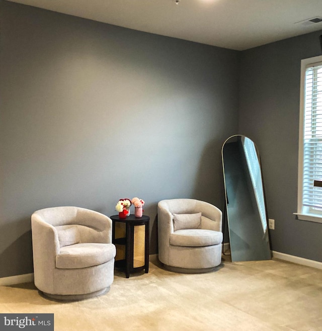 sitting room with carpet flooring, visible vents, and baseboards