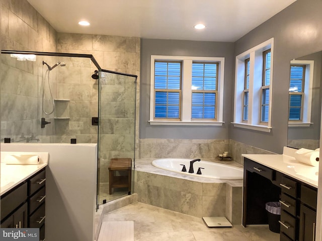 full bathroom with a stall shower, a garden tub, vanity, and recessed lighting