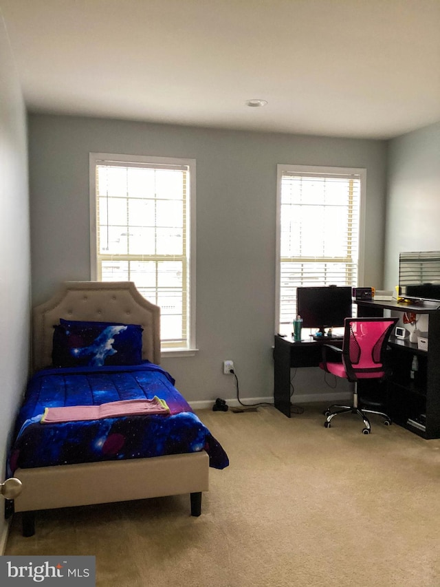 carpeted bedroom featuring multiple windows and baseboards