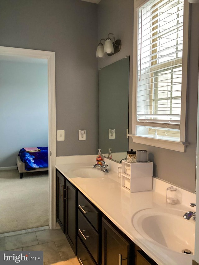 ensuite bathroom with tile patterned floors, a sink, ensuite bath, and double vanity