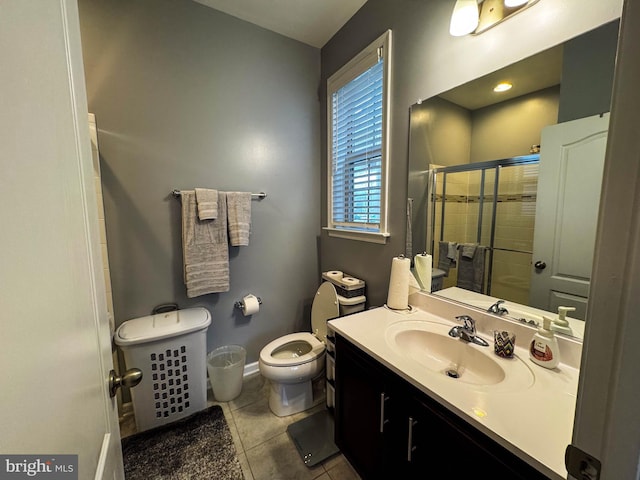 bathroom featuring baseboards, toilet, tile patterned floors, vanity, and a shower stall