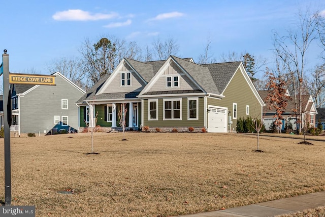 craftsman inspired home featuring a garage, a front yard, and covered porch