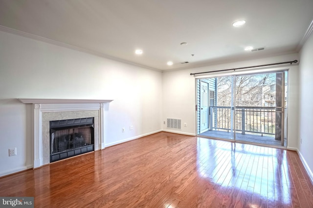 unfurnished living room with hardwood / wood-style flooring, a fireplace, and ornamental molding