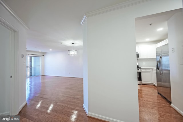 hall with crown molding and light hardwood / wood-style flooring