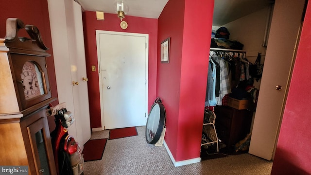 foyer featuring dark colored carpet