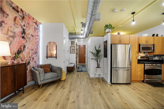 kitchen with appliances with stainless steel finishes and light hardwood / wood-style flooring