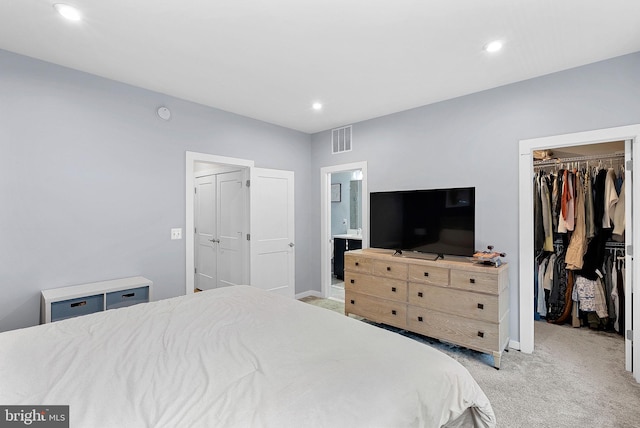 bedroom with recessed lighting, a closet, light colored carpet, visible vents, and a spacious closet