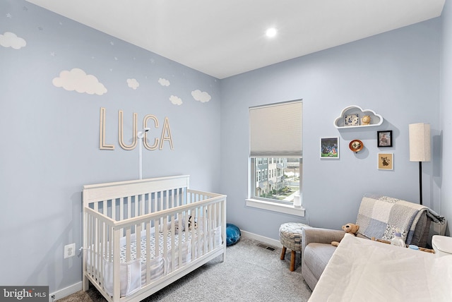 bedroom featuring a nursery area, carpet, visible vents, and baseboards