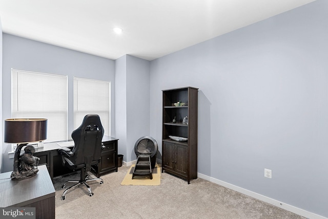 office with baseboards and light colored carpet