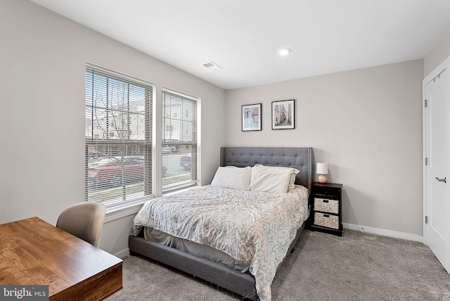 bedroom with light colored carpet, visible vents, and baseboards