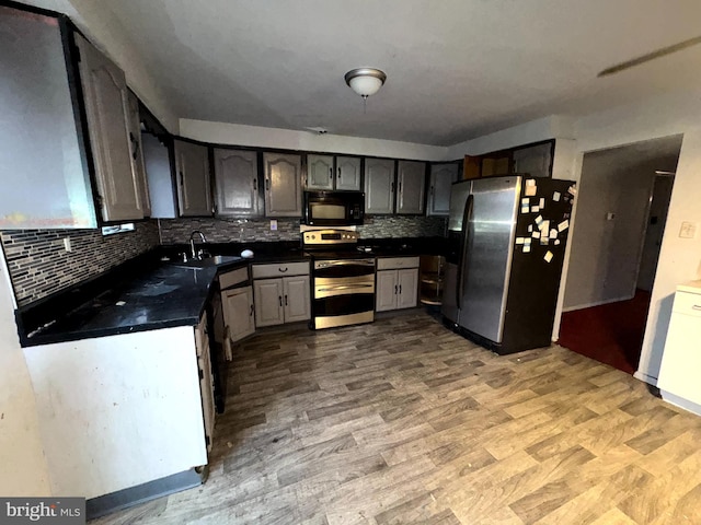 kitchen featuring sink, backsplash, light hardwood / wood-style flooring, and stainless steel appliances