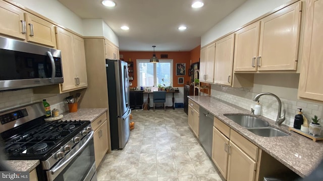 kitchen with sink, hanging light fixtures, stainless steel appliances, light stone countertops, and decorative backsplash