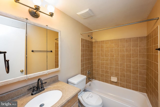 full bathroom with tiled shower / bath, vanity, and toilet