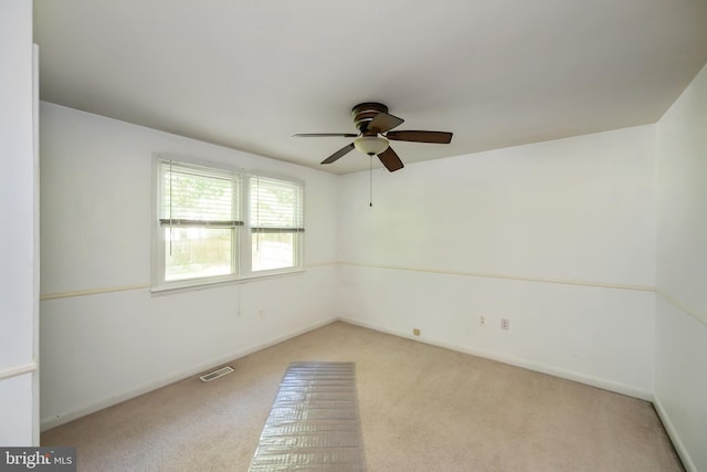 unfurnished room with light colored carpet and ceiling fan