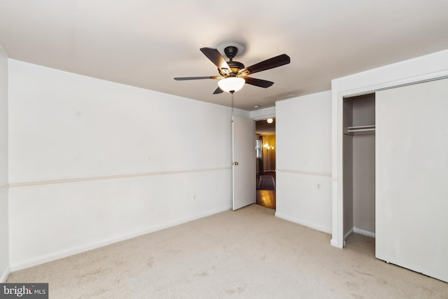 unfurnished bedroom featuring light colored carpet, a closet, and ceiling fan