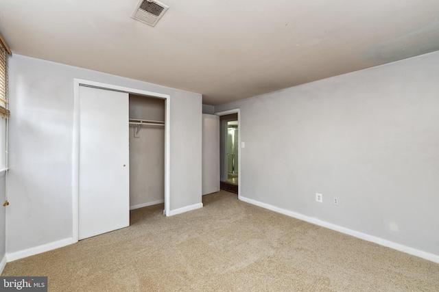 unfurnished bedroom with a closet and light carpet