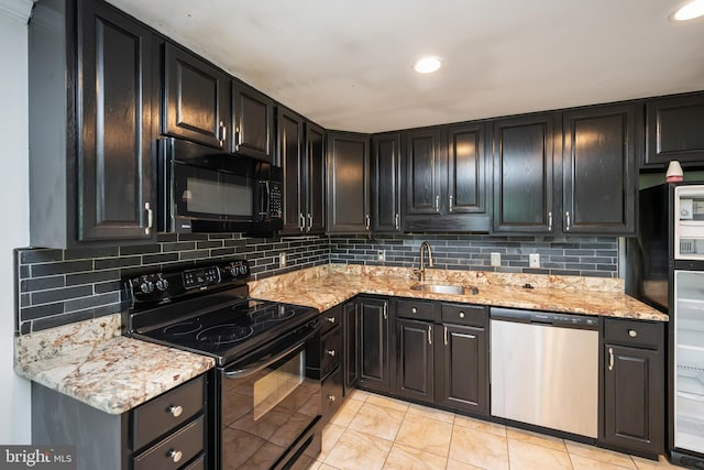 kitchen with sink, decorative backsplash, light stone counters, and black appliances