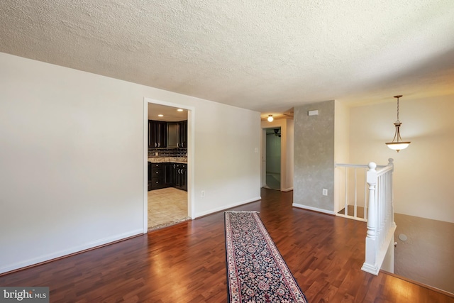 spare room with dark hardwood / wood-style floors and a textured ceiling