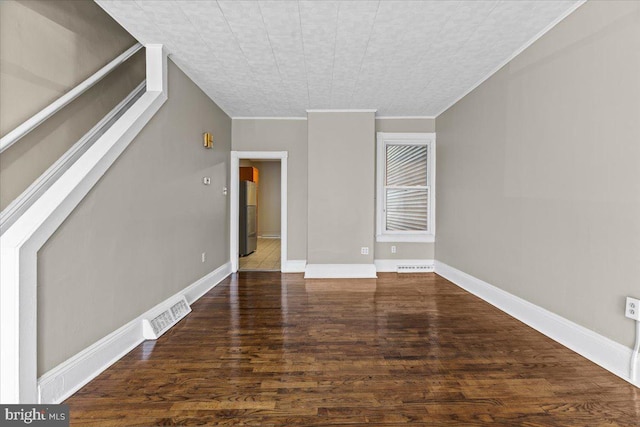 spare room featuring crown molding and dark hardwood / wood-style flooring