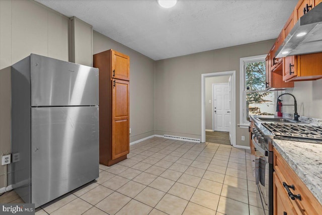 kitchen featuring sink, a textured ceiling, light tile patterned floors, appliances with stainless steel finishes, and light stone countertops