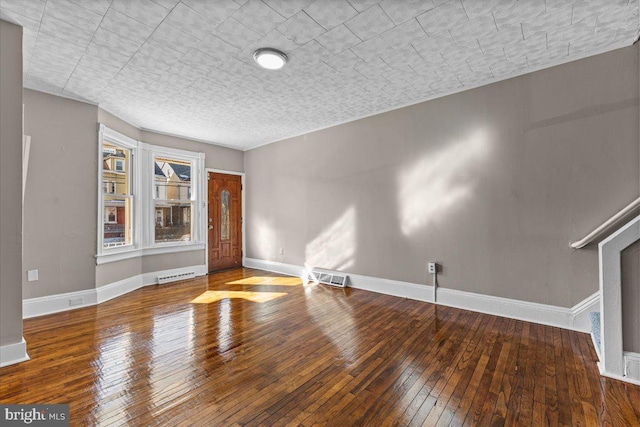 spare room featuring hardwood / wood-style floors and a textured ceiling