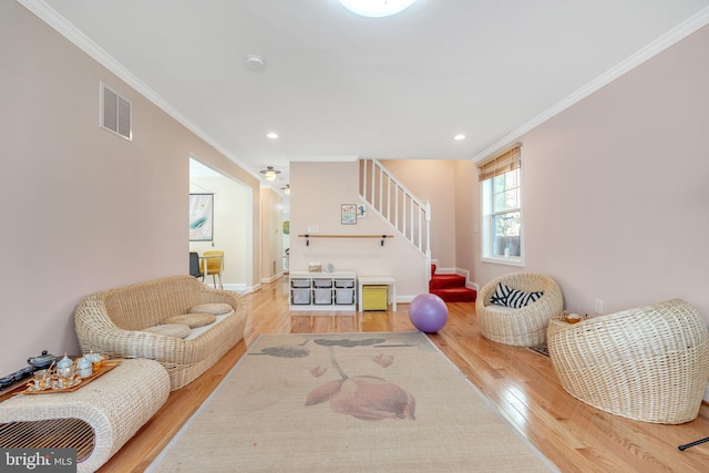 living room with wood-type flooring and ornamental molding