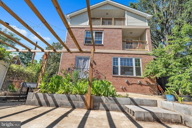 view of front of home with a pergola, a patio area, and a balcony