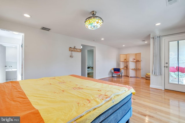 bedroom featuring connected bathroom, access to outside, and hardwood / wood-style floors