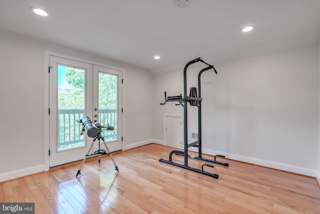 workout room with french doors and light wood-type flooring