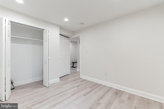 unfurnished bedroom with light hardwood / wood-style flooring and a closet