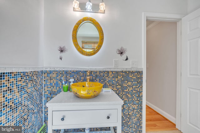 bathroom with tile walls, hardwood / wood-style floors, and vanity