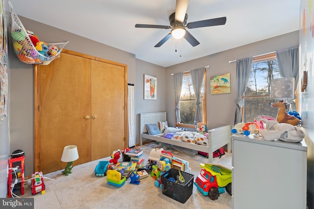 carpeted bedroom featuring ceiling fan, a closet, and multiple windows