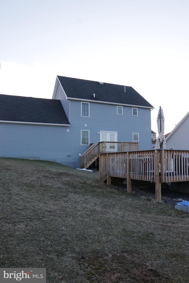 back of house with a wooden deck and a yard