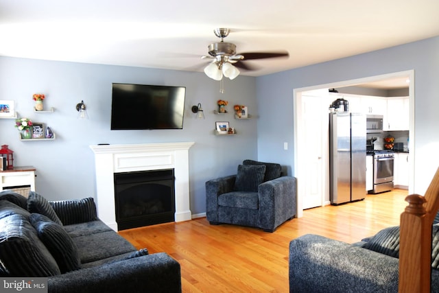 living room featuring ceiling fan and light wood-type flooring