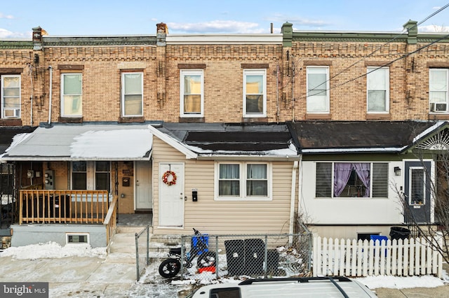 townhome / multi-family property featuring cooling unit and a porch